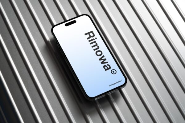 iPhone 14 Pro mockup laying on a classic Rimowa aluminum luggage.