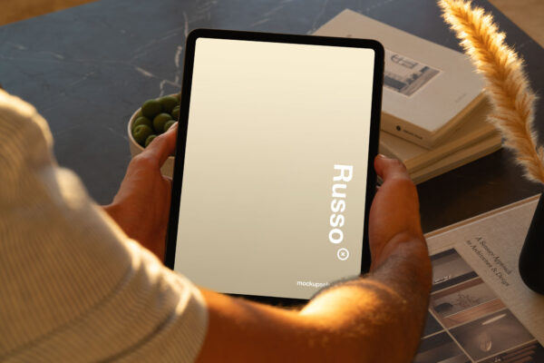 iPad Pro mockup held by a person in a high-end apartment setting.