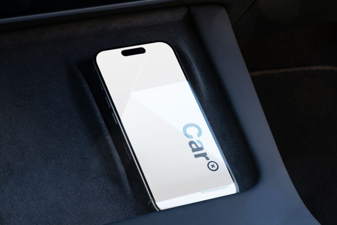 iPhone 15 Pro mockup inside a car’s phone storage area.