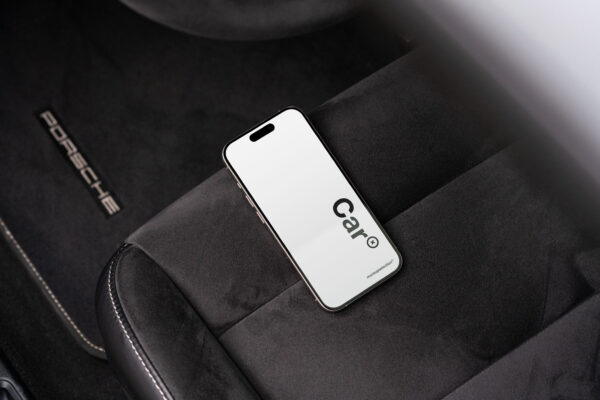 iPhone 15 Pro mockup lying on an Alcantara car seat in a Porsche.
