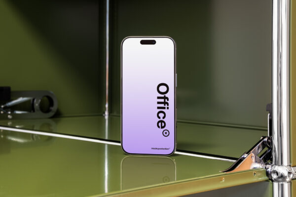 Angled view of iPhone 16 Pro in design office with olive green USM Haller furniture.