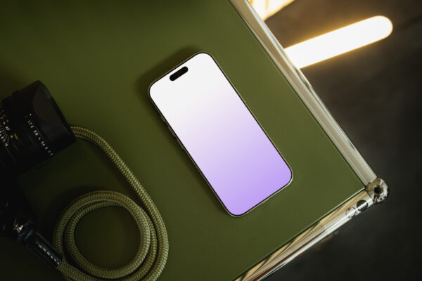 iPhone 16 Pro mockup side view on a green USM Haller furniture piece.