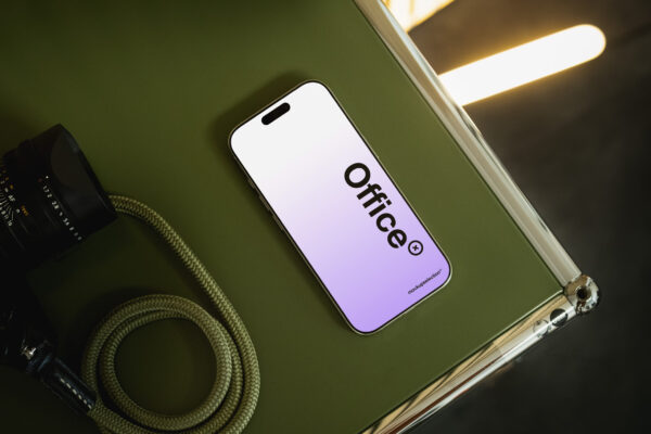 iPhone 16 Pro mockup lying on a green USM Haller furniture piece in a modern office.